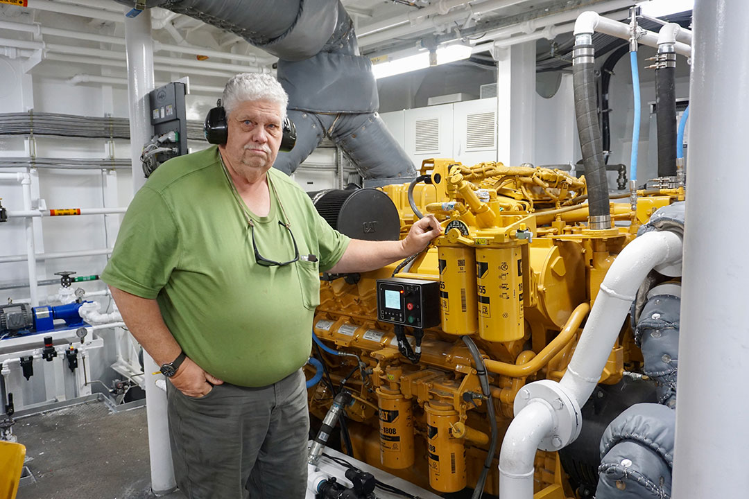 Chief engineer Jack Olson stands alongside a Caterpillar main engine.