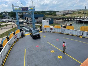 Retired captain Tom Lippincott directs vehicles onto the ferry in Lewes, Del. 