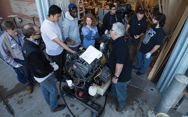 An instructor introduces prospective marine engineers to the workings of a diesel engine.