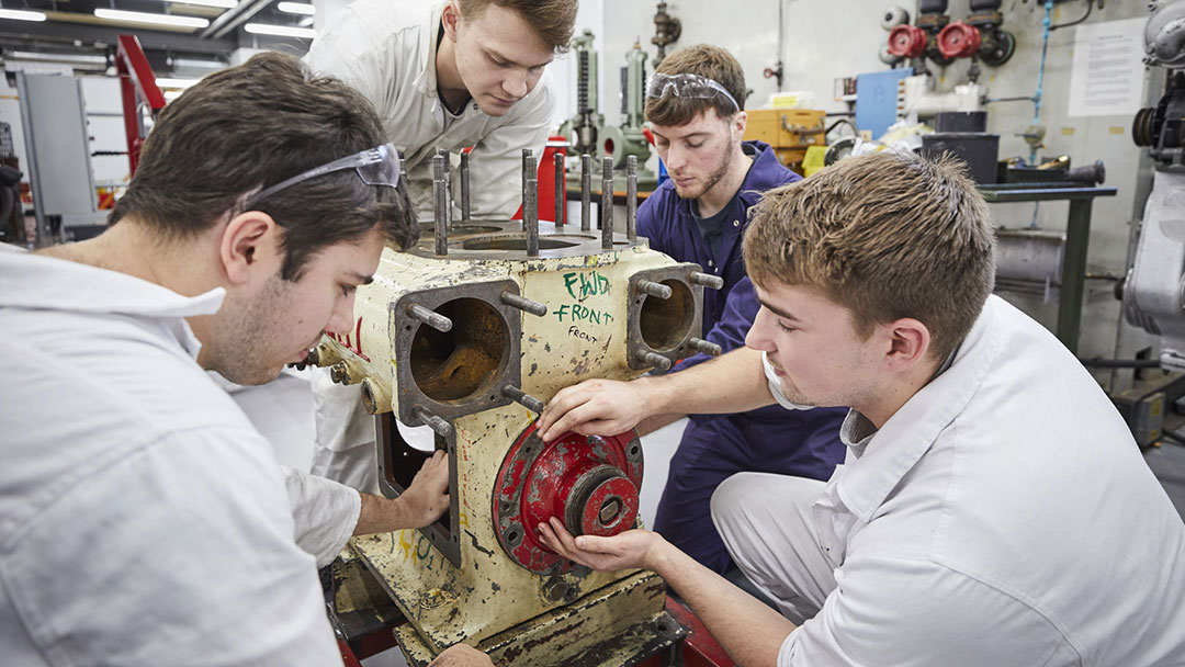 Marine technology students learning the basics of engine maintenance.