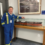 Chief Engineer Jimmy McFadyen with a model of Crowley’s 16,000 hp ATB Liberty and a 330,000 barrel 750-class barge.