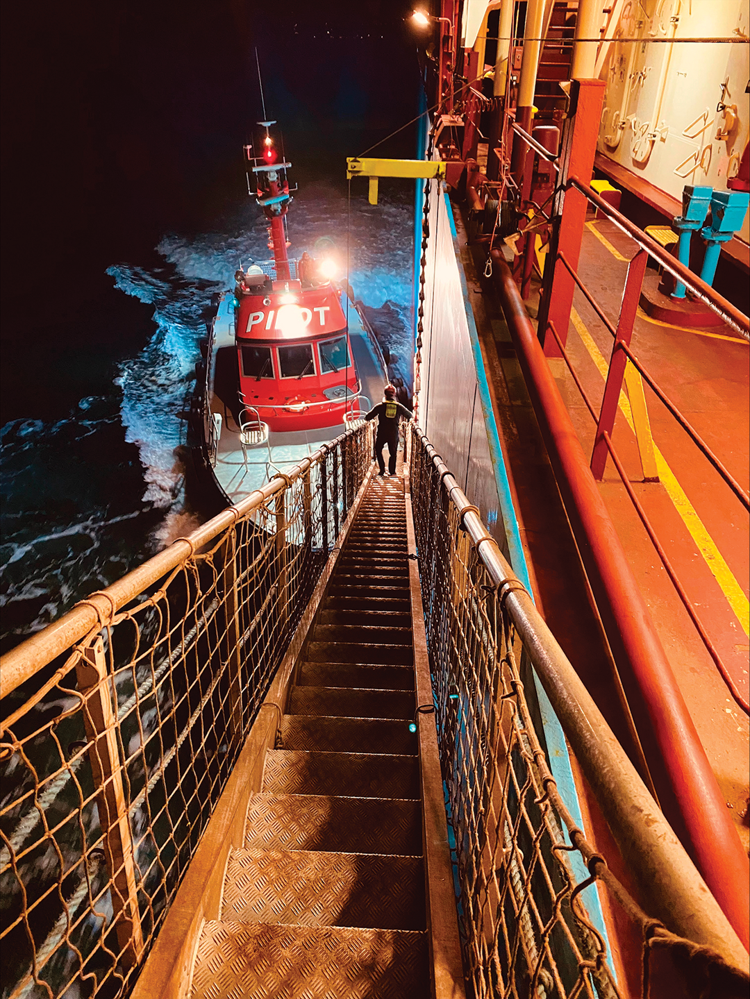 An early morning job done, a Puget Sound pilot descends an outbound ships accommodation ladder.
