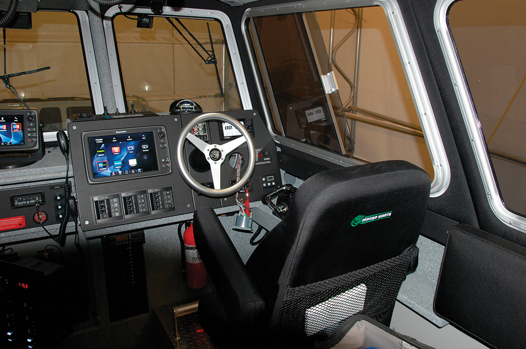 The fireboat’s cabin is fitted with ballistic nylon upholstered crew seats and instrumentation including 12-inch MFD screens with chart plotter/radar overlay, VHF radios, and engine displays