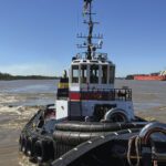 Capt. Joseph Bisso, background, pushes Mr. Brian, foreground, on the Mississippi River last year.