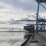 View of a North Charleston Terminal STS crane extending over the side of a cargo ship and the Cooper River. The containership’s mooring configuration is similar to Celsius Nicosia’s configuration when the crane on Stevens 1471 contacted the STS crane. The cargo ship pictured has a 131-foot beam, 26 feet wider than Celsius Nicosia.