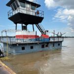 The partially sunk towboat Cajole, as seen in June 2024 secured to a barge after all involved personnel safely disembarked the vessel.