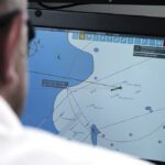 Opposite, a remote maritime pilot at DanPilot’s operations center monitors live navigational data and radar feeds during Denmark’s remote pilotage test program. Although the core technology has been discussed and demonstrated for more than two decades, conventional onboard pilotage remains highly effective, with a safety record that has dampened industry demand for remote alternatives.