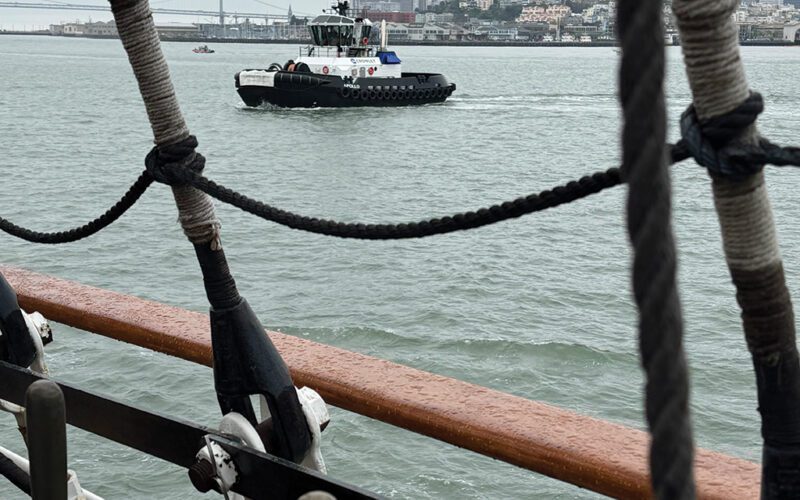 The Crowley tug Apollo stands by as the U.S. Coast Guard Barque Eagle enters San Francisco Bay on a cold, foggy morning in June 2025.