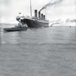 HMS Titanic departs Belfast, Ireland, on April 2, 1912, less than two weeks before its tragic sinking. Five tugs assisted the liner’s departure, although only two are visible in this image.
